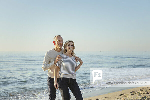 Smiling couple near seashore at beach