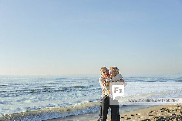Happy man embracing woman at beach