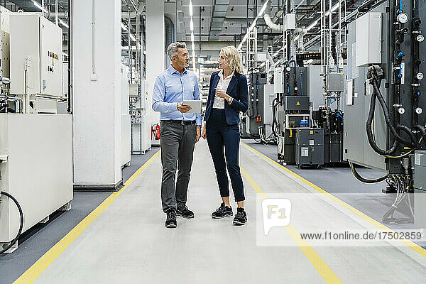 Businesswoman having discussion with colleague at modern industry