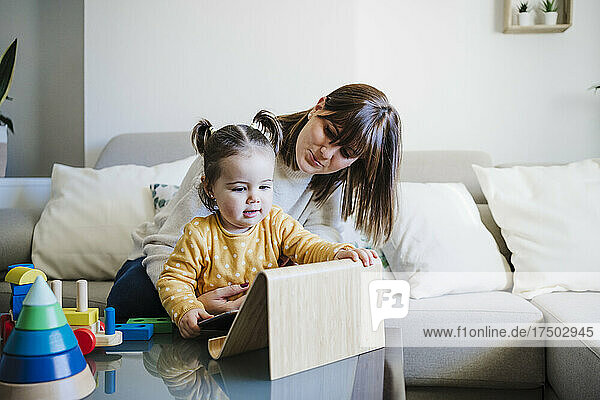 Mother and daughter with tablet PC on table
