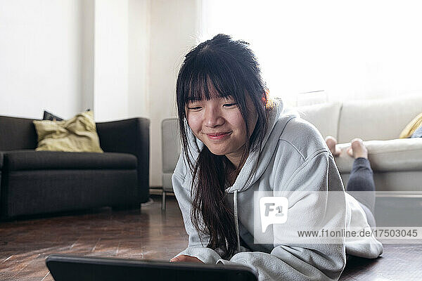 Smiling woman using tablet PC at home