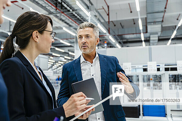 Businessman explaining coworkers in automated industry