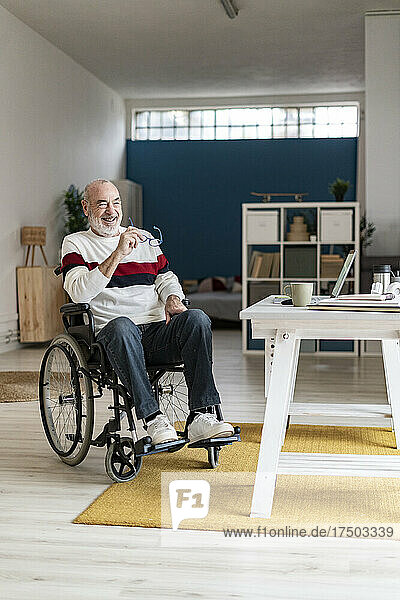 Smiling disabled businessman on wheelchair at home