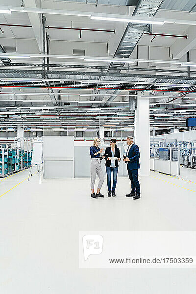 Businesswoman discussing with colleagues in modern industry