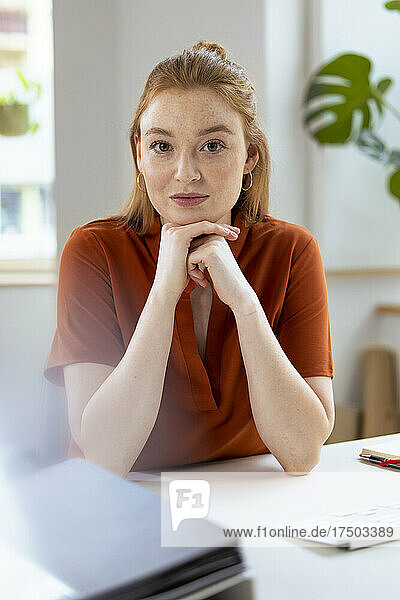 Businesswoman with hand on chin at desk