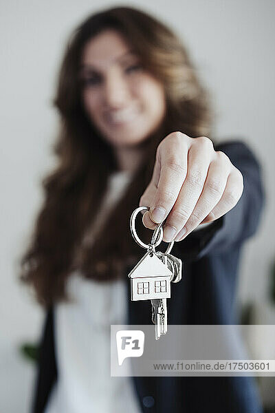 Real estate agent holding house keys at office