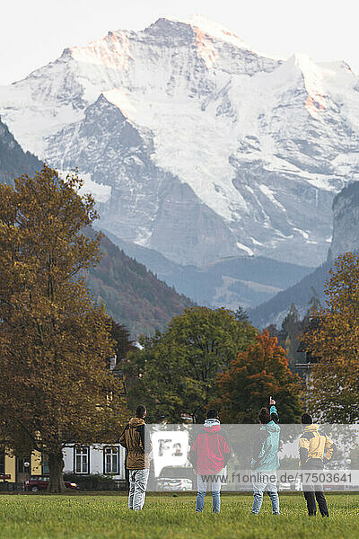 Man showing mountain to friends at Iseltwald  Interlaken  Switzerland