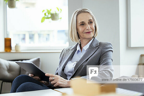 Blond businesswoman with tablet PC at workplace