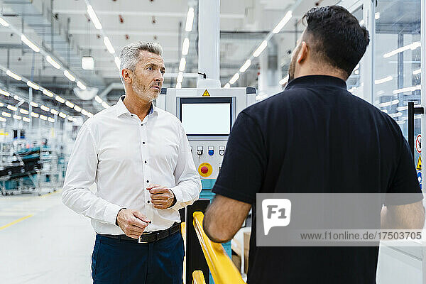 Businessman discussing with maintenance engineer at electrical industry