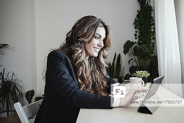Smiling businesswoman using tablet PC at office