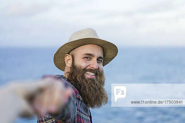 Smiling hipster man holding hand of girlfriend