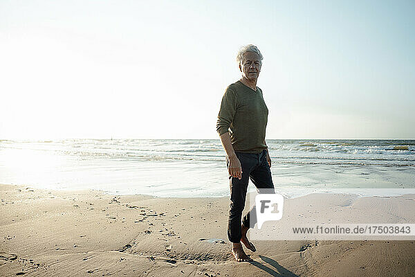Älterer Mann läuft auf Sand am Strand