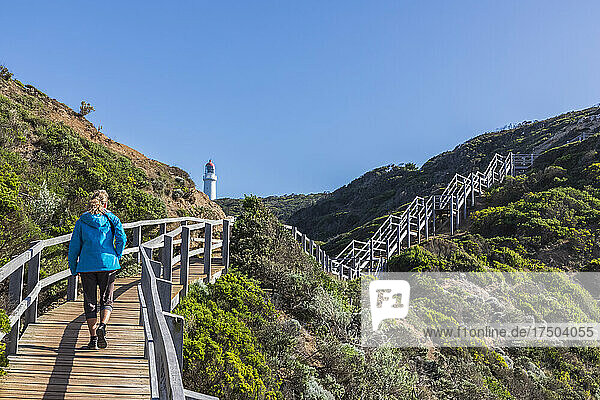 Australia  Victoria  Cape Schanck  Female tourist walking along boardwalk leading to Cape Schanck Lighthouse