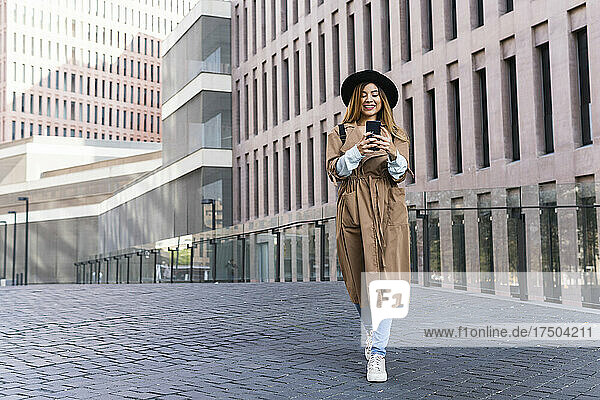 Woman using mobile phone at city street