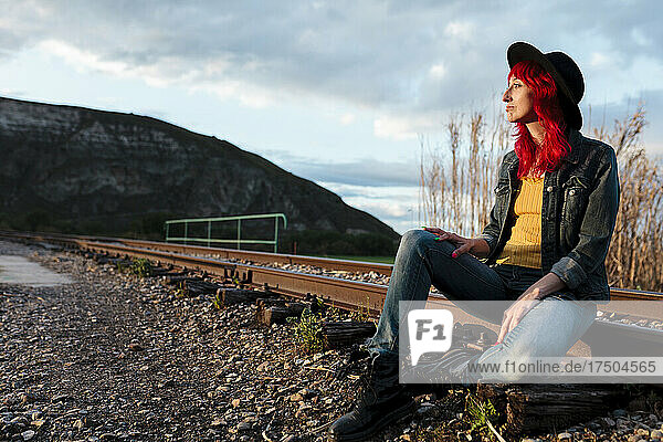 Woman contemplating sitting on railroad track