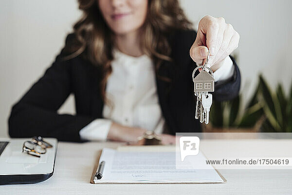 Young saleswoman holding house keys