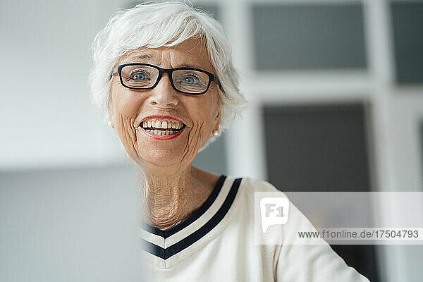 Happy senior woman with laptop at home