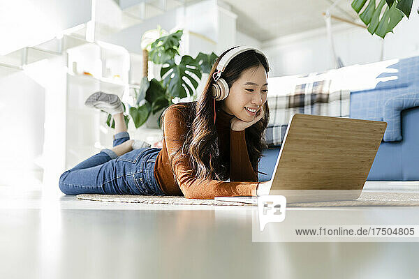 Young freelancer using laptop on floor at home
