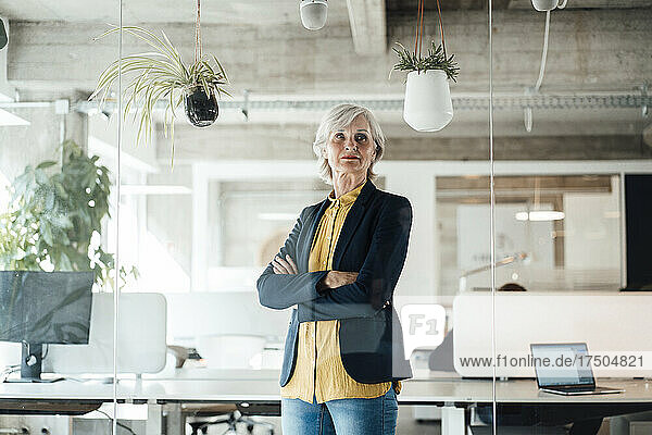 Senior businesswoman with arms crossed at office