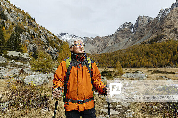 Smiling hiker with hiking poles on mountain at Rhaetian Alps  Italy