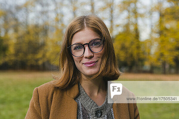 Schöne Frau mit Brille lächelt im Park