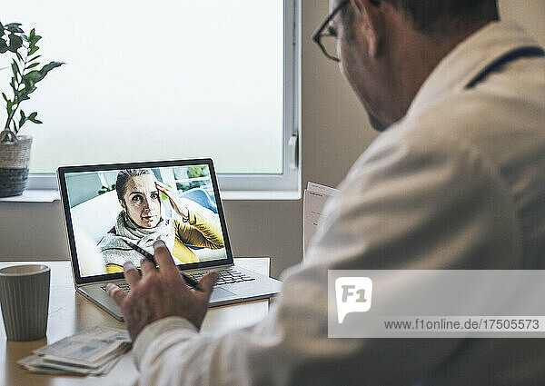 Patient with headache talking to doctor on video call at clinic