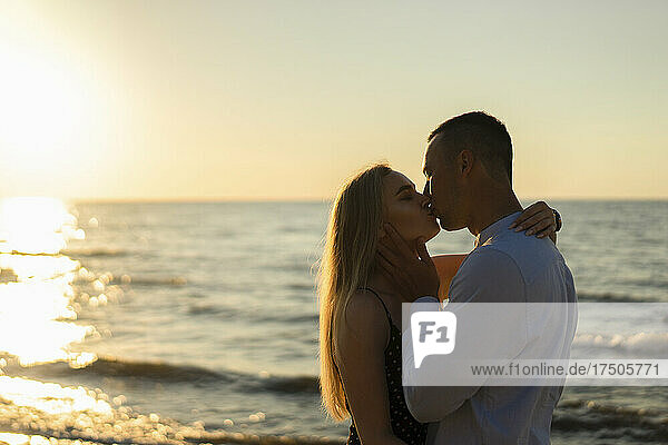 Romantic couple kissing at sunset
