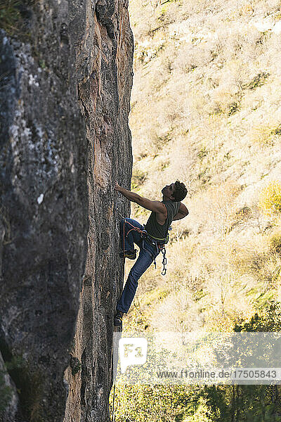 Wanderer klettert auf Felsenberg