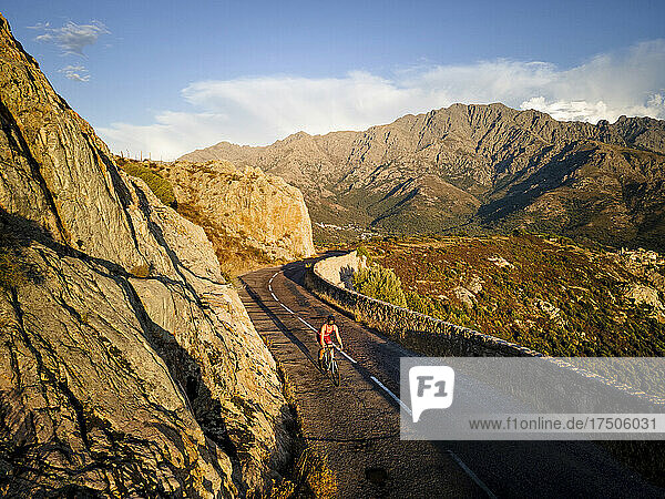 Sportswoman cycling on road by mountain