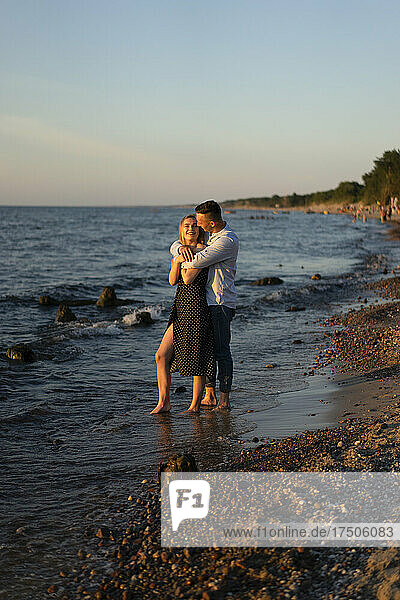 Man embracing woman at beach shore