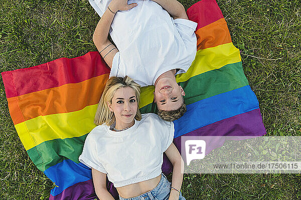 Young lesbian couple lying on rainbow flag