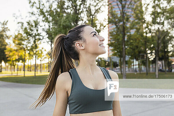 Smiling athlete looking away in public park