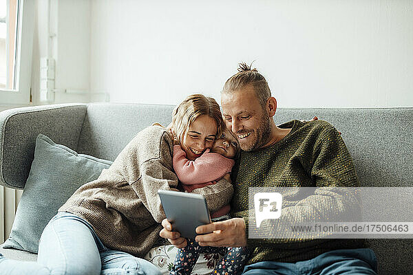 Glückliche Familie  die zu Hause einen Tablet-PC nutzt