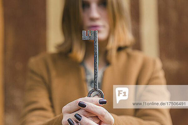 Young woman holding old key