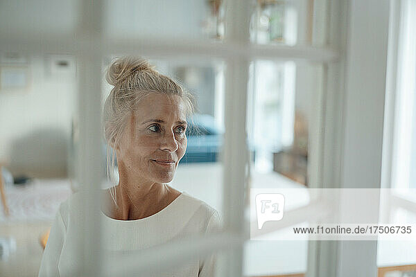 Woman looking out of window at home