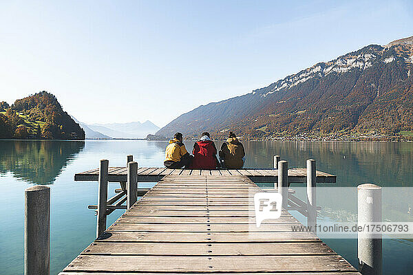 Friends sitting on pier and looking at mountains at Interlaken  Switzerland