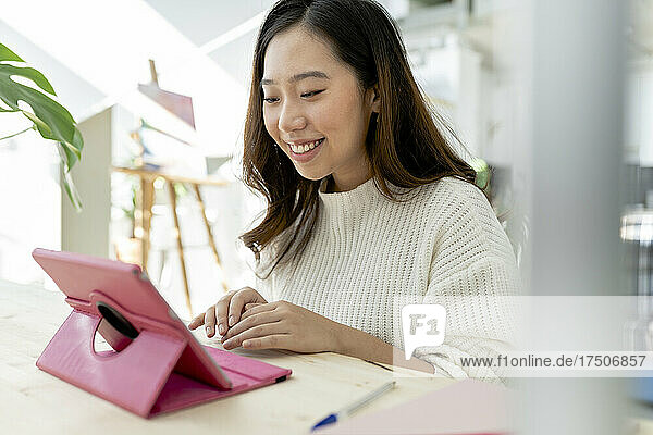 Businesswoman attending video call through tablet PC at home