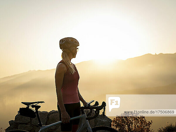 Sportswoman wearing helmet looking at sunset