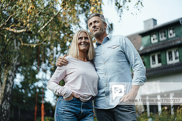 Couple with hands in pockets at backyard