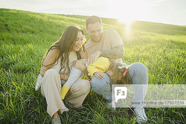 Man and woman playing with daughter on sunny day