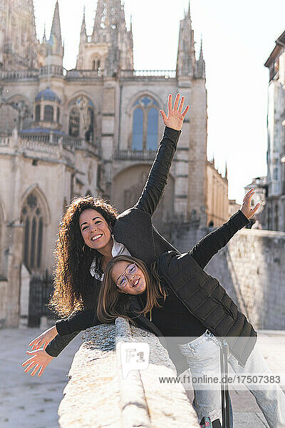 Happy woman and girl with arms outstretched at Burgos Cathedral  Burgos  Spain