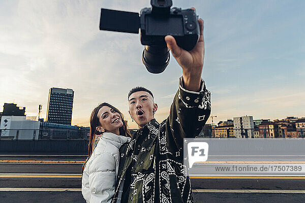 Man and woman taking selfie through digital camera