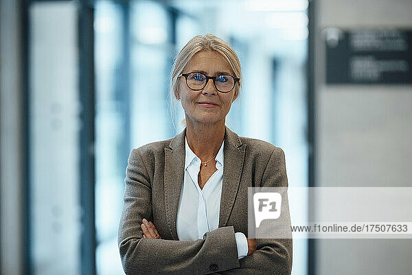 Confident businesswoman with arms crossed in office