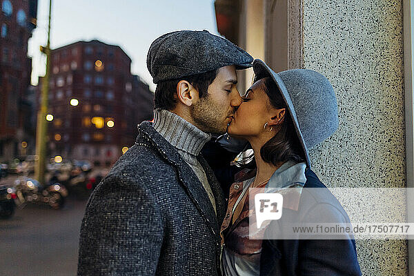 Junges  liebevolles Paar küsst sich mit geschlossenen Augen in der Stadt