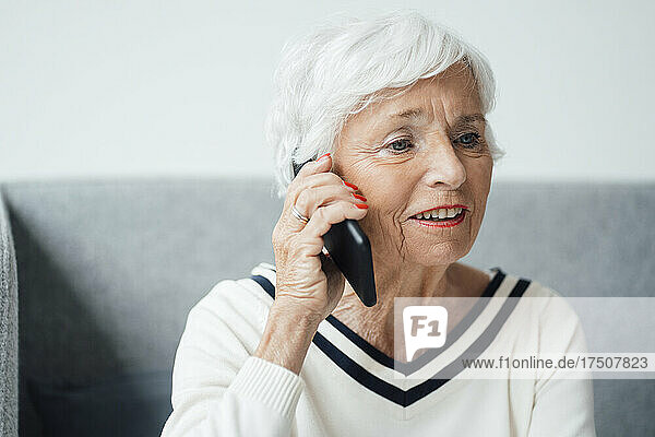 Senior woman talking on mobile phone at home