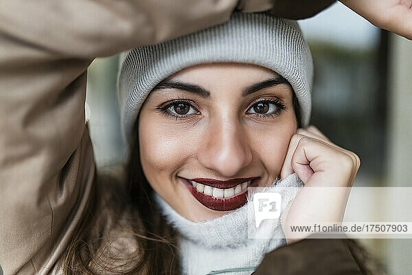 Beautiful woman with lipstick smiling holding sweater
