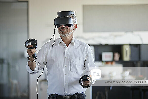 Businessman playing with virtual headset at work place