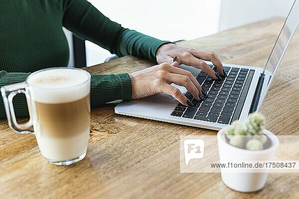 Freelancer using laptop at cafe table