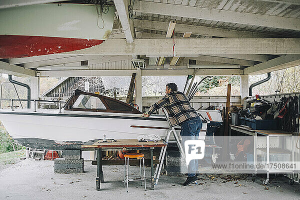 Älterer Mann repariert Schnellboot in Garage
