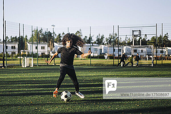 Weibliche Athletin spielt Fußball auf einem Sportplatz